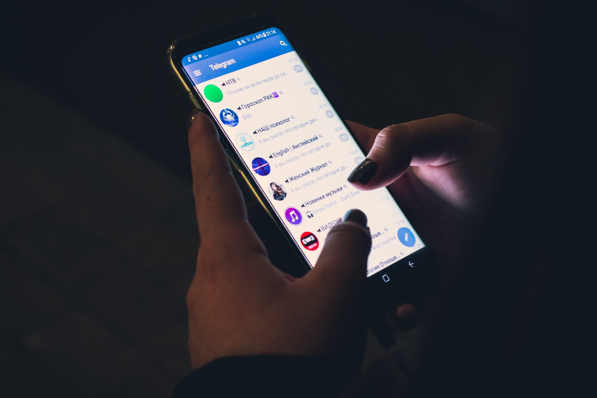 hands typing on a phone showing Telegram chats